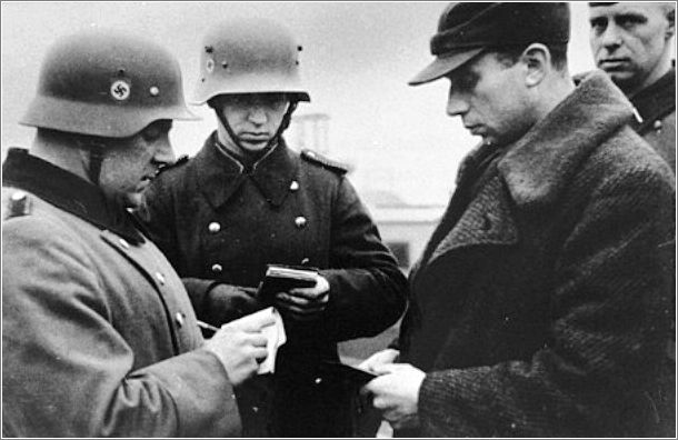 German police or soldiers check the identification papers of a Jew in the streets of Krakow